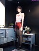 A woman in a white top and red shorts standing in a room.