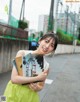 A woman in a green dress holding a book.