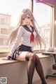 A girl in a school uniform sitting on a window sill.